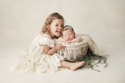 Séance photo naissance à Dijon : bébé dans un panier avec sa grande sœur