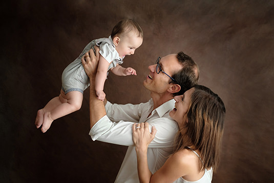 Parents et leur bébé sur fond brun