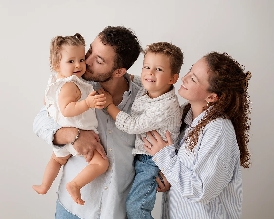 Famille avec les parents et leurs 2 enfants se regardant et s'embrassant