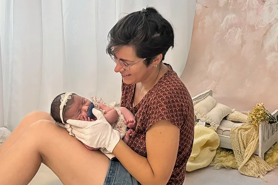 Vanessa Bureau, photographe naissance à Dijon, tenant délicatement un nouveau-né au studio